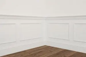 Freshly painted white interior trim and wall paneling in a finished room, showing clean lines and smooth results when you can you paint interior trim in cold weather conditions.