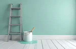 Interior painting setup showing a mint green wall, ladder, and paint bucket, illustrating how to plan a spring paint refresh for your Northville home.
