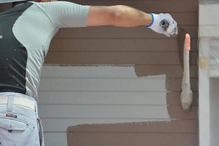 Professional painter applying fresh exterior paint to siding, showing what affects the cost of exterior painting in Bloomfield Hills