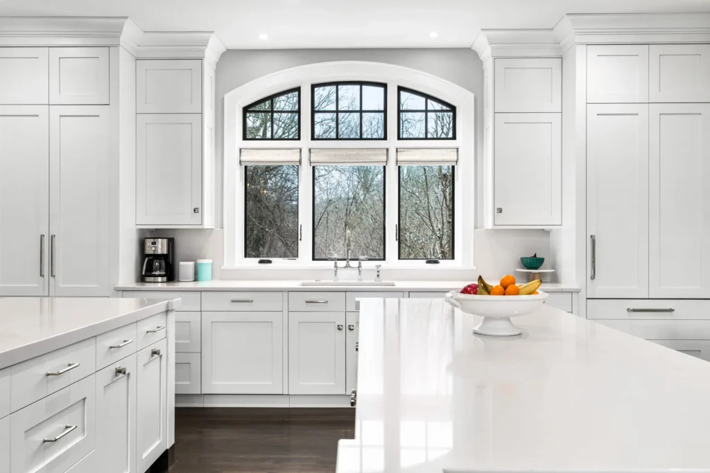 Pro Painters LTD in Metro Detroit image featuring a modern white kitchen with floor to ceiling built-ins, island and sink
