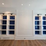 Custom built-ins with white high gloss shelving and deep blue high-gloss back panels